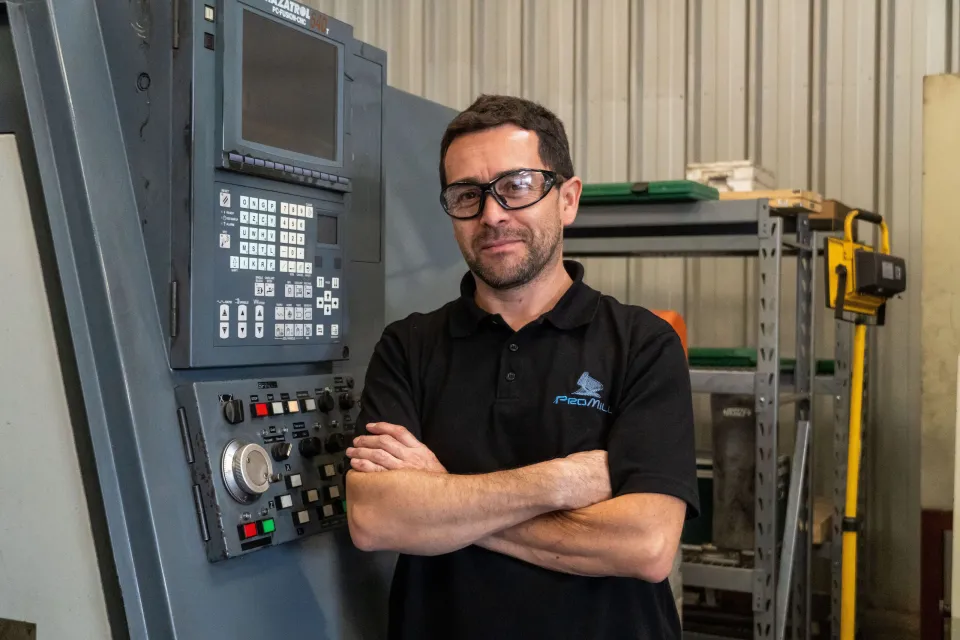 Integrante del equipo Promill junto al panel de un torno CNC